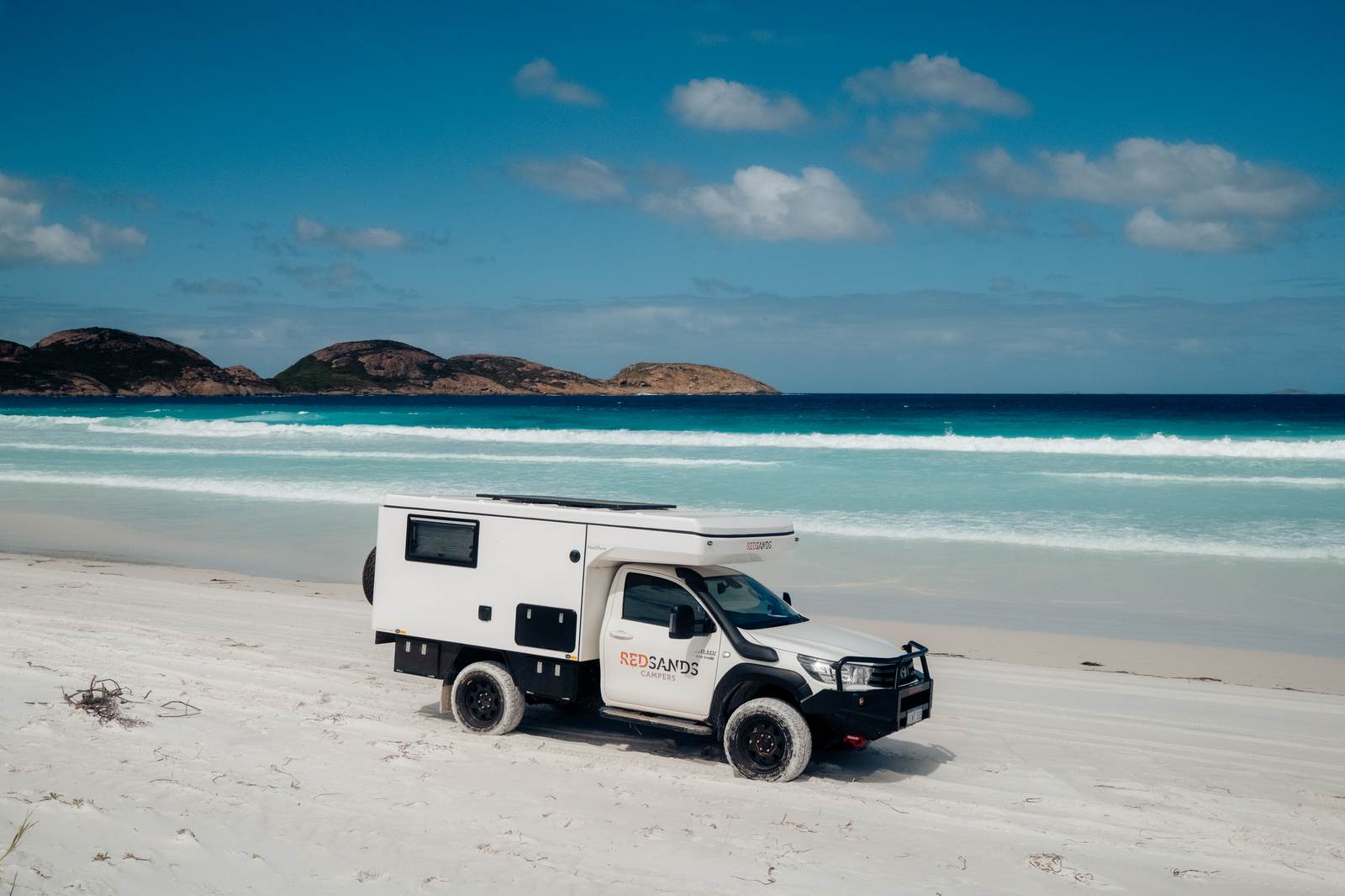 Wanderer Luxe parkte einsam an einem weißen Sandstrand